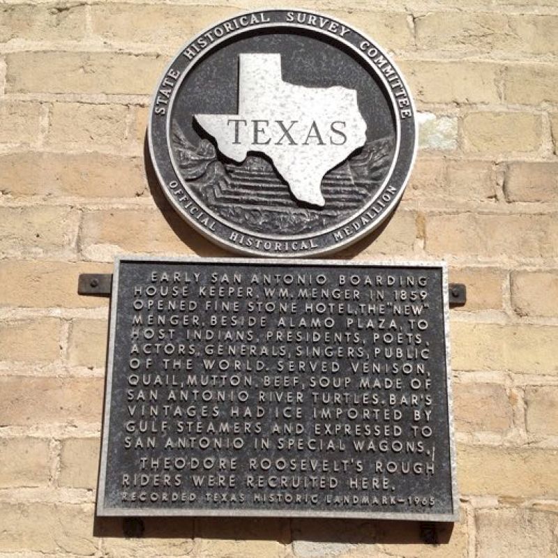 Texas historical marker on a brick wall with a round Texas shape badge above a plaque describing local history.